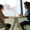 Franchise Candidate Financing Support: SBA and Lender Handoffs Without Killing Deal Velocity 6 Franchise candidate and advisor talking across a table in an office with city views