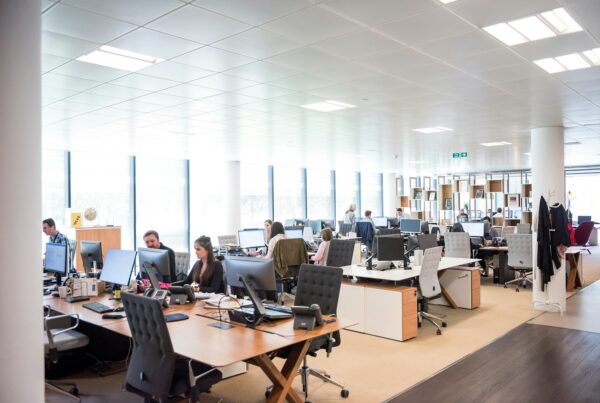 Franchise sales team working at open-office desks following up with candidates on computers and phones