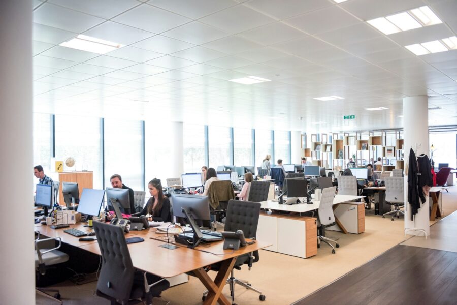 Franchise sales team working at open-office desks following up with candidates on computers and phones