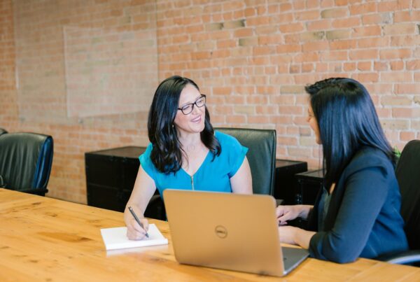 Franchise Candidate Scorecard: Early Disqualification Gates That Protect Your Brand 3 Franchise development interviewer taking notes while meeting a candidate at a conference table
